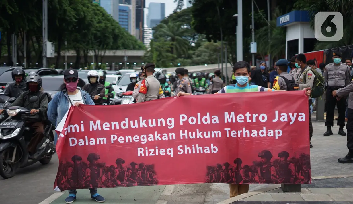 Massa yang tergabung dalam Aliansi Anak Bangsa Cinta Kedamaian membawa spanduk saat menggelar aksi unjuk rasa menuntut aparat kepolisian segera menangkap Rizieq Shihab atas dugaan pelanggaran protokol kesehatan di depan Gedung Polda Metro Jaya, Jakarta, Senin (7/12/2020). (Liputan6.com/Immanuel Anto