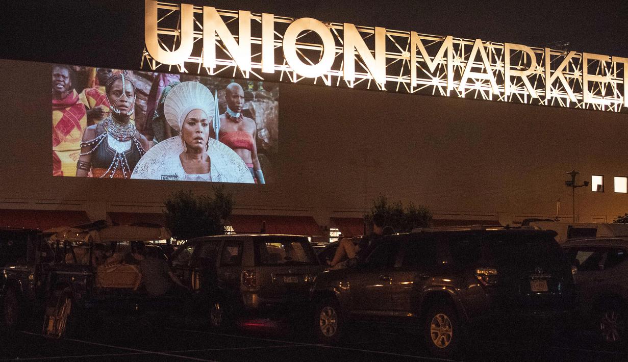 Puluhan mobil terparkir di depan layar bioskop saat pemutaran film drive-in di Family Drive-in di Virginia, 10 Agustus 2018. Menonton film di luar ruangan atau drive-in merupakan bagian penting dalam industri hiburan di Amerika. (AFP PHOTO/Nicholas Kamm)