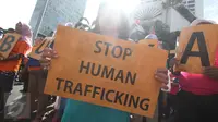 Peserta aksi damai membawa poster bertuliskan 'Stop Human Trafficking' di kawasan Bundaran HI, Jakarta, Minggu (18/12). Aksi yang digelar PRT Migran tersebut dalam rangka memperingati Hari Migran Internasional 2016. (Liputan6.com/Immanuel Antonius)
