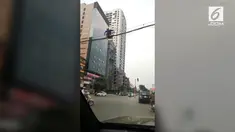 Lelah menunggu waktu menyebrang karena jalanan yang padat, membuat seorang pejalan kaki di Hanoi, Vietnam, nekat melintasi kabel listrik.