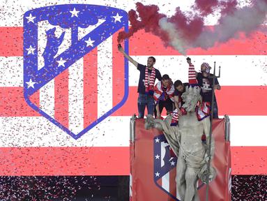 Para pemain Atletico Madrid merayakan gelar Liga Europa dengan menaiki air mancur Neptune di Madrid, Jumat (18/5/2018). Kota Madrid menjadi merah saat perayaan gelar juara Atletico. (AFP/Javier Soriano)