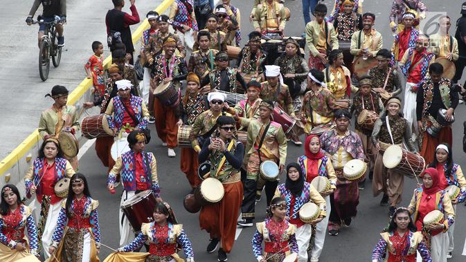 Peserta menggunakan pakaian tradisional turut meramaikan pawai obor Asian Para Games 2018 di Jakarta, Minggu (30/9). Nantinya api obor ini akan diarak di 17 titik lokasi di Ibu Kota. (Liputan6.com/Herman Zakahria)