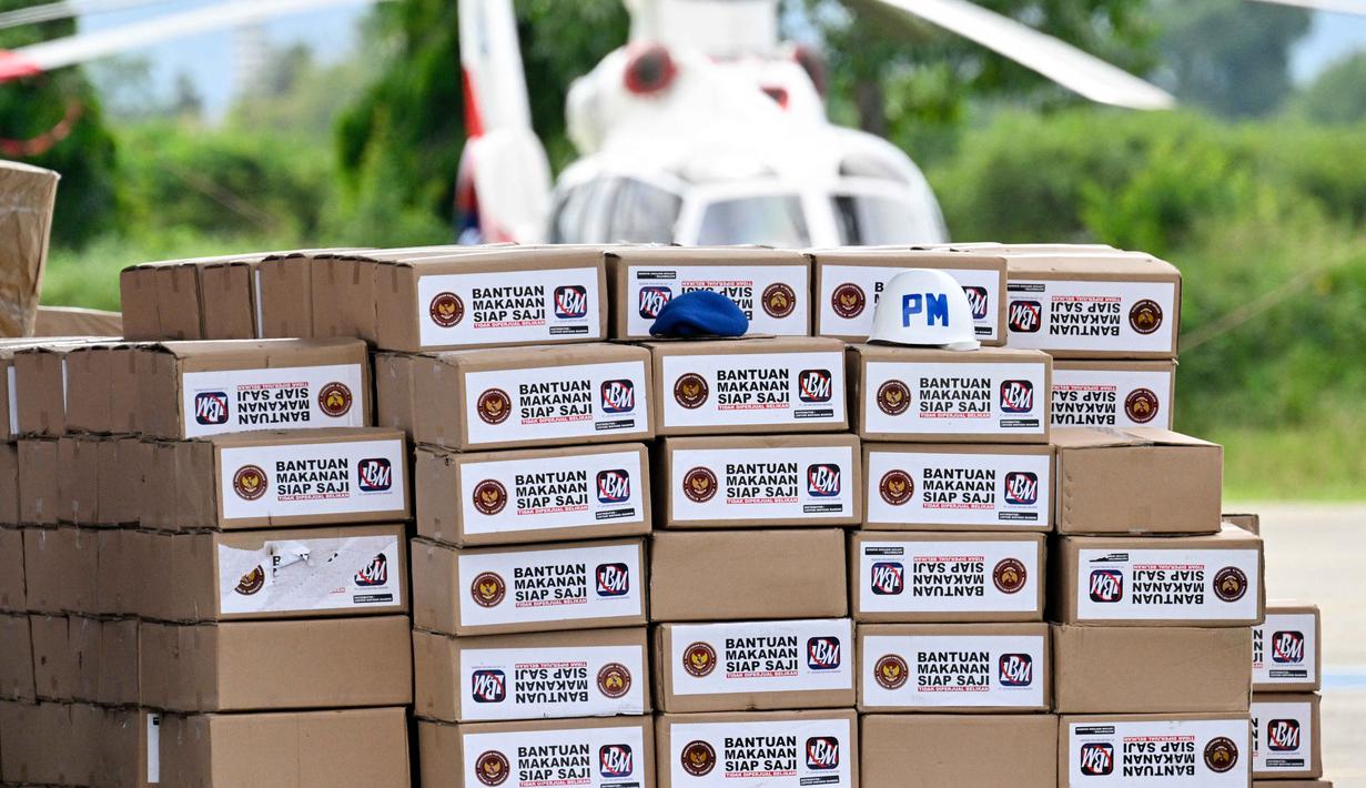 Tidak hanya itu, 36 unit helikopter dari beragam jenis juga dioperasikan untuk misi penyelamatan dan distribusi bantuan logistik ke sejumlah wilayah terdampak. Tampak dalam foto, bantuan untuk korban banjir sedang disiapkan di Pangkalan Tentara Nasional Indonesia (TNI) Angkatan Udara (AU) di Blang Bintang, Provinsi Aceh, pada Minggu 7 Desember 2025. (Chaideer MAHYUDDIN/AFP)