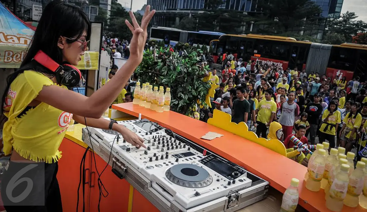 Seorang DJ meramaikan Coolant Star Fruit di arena Car Free Day, Jakarta, Minggu (25/9). Di acara tersebut, Coolant membagikan bibit belimbing untuk mengajak masyarakat melestarikan lingkungan dengan menanam tanaman produktif.  (Liputan6.com/Faizal Fanani)