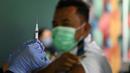 Seorang petugas kesehatan menyiapkan suntikan vaksinasi COVID-19 keempat atau booster kedua untuk petugas bandara di kantor otoritas Bandara Ngurah Rai, dekat Denpasar, Bali, Senin (30/1/2023). Para pekerja di bandara ini merupakan garda terdepan yang berinteraksi langsung dengan pelaku perjalanan luar negeri atau PPLN. (SONNY TUMBELAKA / AFP)