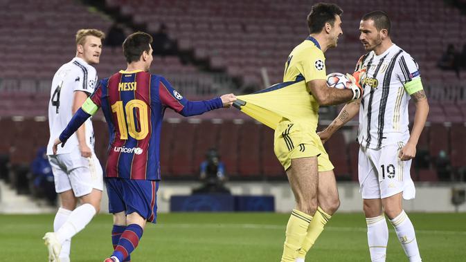 Striker Barcelona, Lionel Messi, menarik baju kiper Juventus, Gianluigi Buffon, pada laga Liga Champions di Stadion Camp Nou, Rabu (9/12/2020). Aksi La Pulga tersebut karena merasa frusatsi gagal membobol gawang Buffon. (AFP/Josep Lago)