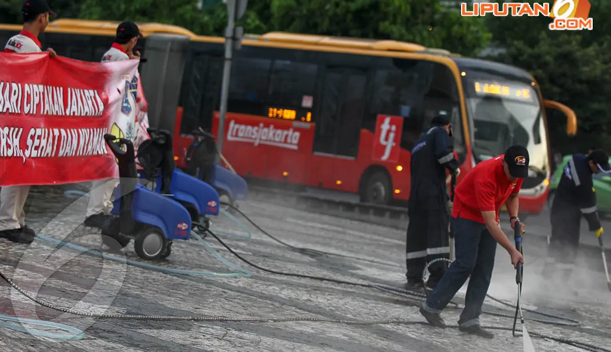 Beberapa petugas membersihkan lumut-lumut yang mengotori lantai Bundaran HI dengan alat penyemprot air bertekanan tinggi, Sabtu (19/4/14). (Liputan6.com/Faizal Fanani)