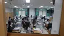 Siswa menunggu kelas dimulai dengan pembatas plastik di atas meja di Jeonmin High School di Daejeon, Korea Selatan, Rabu (20/5/2020). Korea Selatan akhirnya membuka kembali kegiatan belajar di kelas untuk siswa menengah atas setelah sempat tertunda hingga lima kali. (Kim Jun-beom/Yonhap via AP)