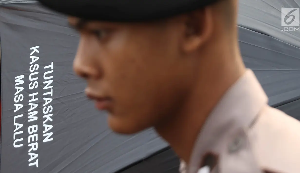 Petugas berjaga saat aksi diam Kamisan ke-540 di depan Istana Merdeka, Jakarta, Kamis (31/5). Para aktivis menuntut agar Presiden Joko Widodo menyelesaikan kasus perkosaan, pembunuhan, dan kerusuhan peristiwa 1998. (Liputan6.com/Immanuel Antonius)