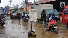 Kondisi jalan berlubang dan tergenang air di Jalan Raya Pabuaran, Citayam, Depok, Rabu (26/2/2020). Kerusakan disebabkan oleh kubangan air yang menggenangi jalan tersebut pada musim hujan yang melanda Jabodetabek dua bulan terakhir. (merdeka.com/magang/Muhammad Fayyadh)