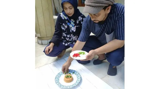 Potret candid Tompi dan Arti Indira saat menyiapkan makanan.