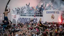 Suporter Real Madrid menyambut timnya saat tiba di Plaza Cibeles, Madrid, Senin (29/5/2016) dalam parade juara Liga Champions. (AFP/Pedro Armestre)