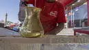 Pembuat penganan Mesir Mostafa Anwar membuat makanan penutup tradisional yang disebut "Kunafa" sebelum berbuka puasa, di kiosnya di ibu kota Kairo pada 14 April 2022.  Kunafa merupakan hidangan pencuci mulut utama di kalangan orang Arab selama Ramadhan berlangsung. (Khaled DESOUKI/AFP)