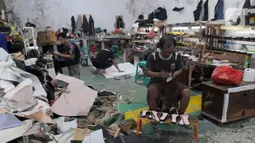 Perajin alas kaki menyelesaikan pembuatan sandal di kawasan Bojongsari, Depok, Jawa Barat, Selasa (22/2/2022). Dalam sebulan, perajin mampu menghasilkan 1.200 pasang sandal dengan harga Rp 30 ribu/pasang hingga Rp 200 ribu/pasang. (merdeka.com/Arie Basuki)