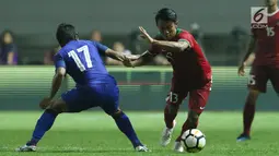 Gelandang Timnas Indonesia U-23, Febri Hariyadi (kanan) mencoba melewati adangan pemain Thailand U-23, Jakkit Wachpirom pada laga persahabatan di Stadion Pakansari, Kab Bogor, Minggu (3/6). Laga berakhir imbang 0-0. (Liputan6.com/Helmi Fithriansyah)