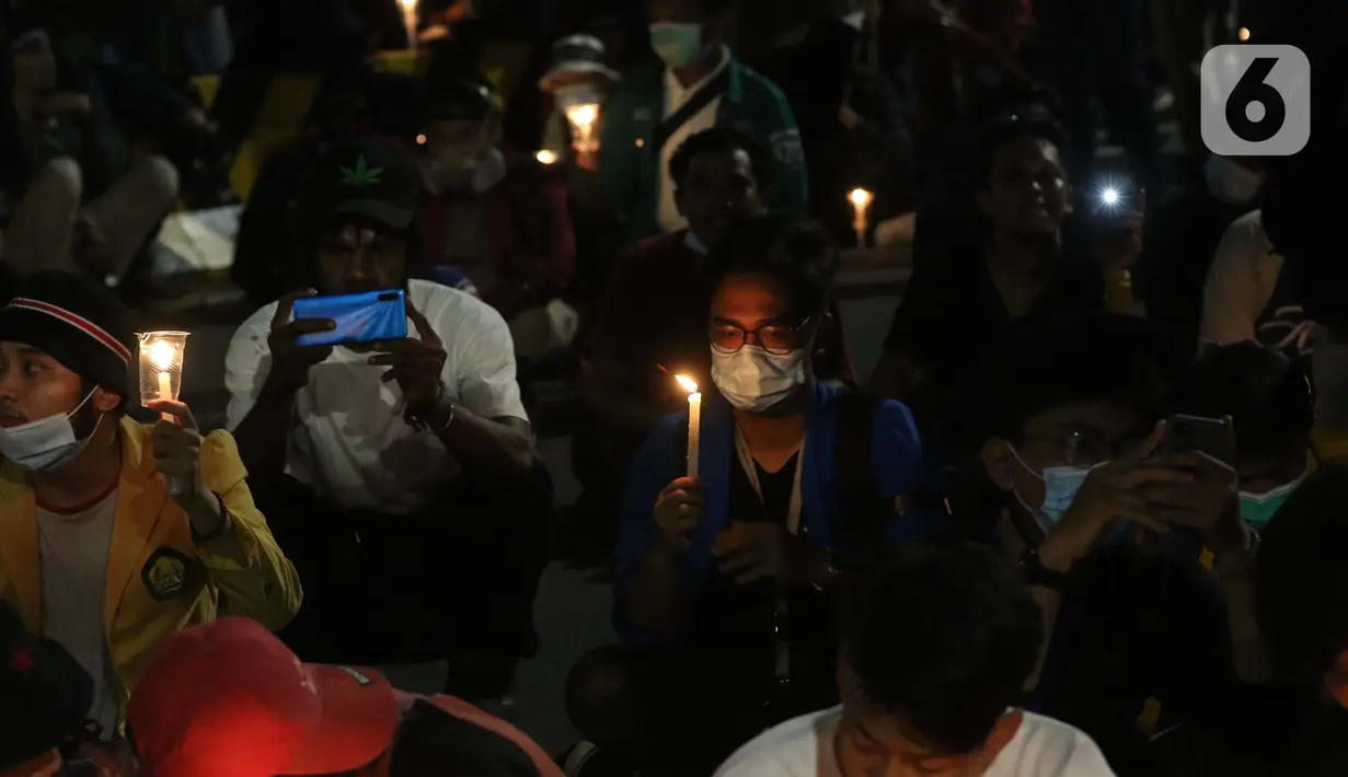 Beberapa peserta aksi unjuk rasa memegang lilin saat doa bersama lintas agama di Kawasan Patung Kuda, Jakarta, Selasa (10/11/2020). Sejumlah massa gabungan dari berbagai organisasi buruh dan mahasiswa berunjuk rasa menolak pengesahan Omnibus Law UU Cipta Kerja. (Liputan6.com/Helmi Fithriansyah)
