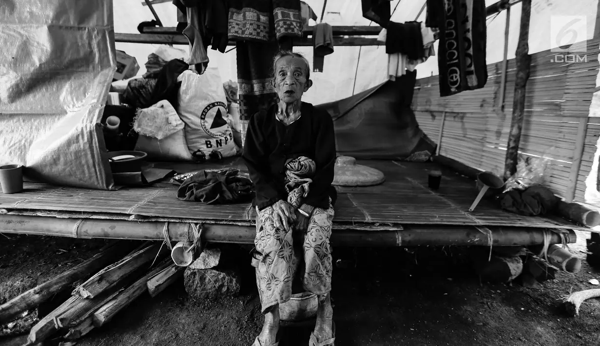 Seorang nenek Suku Baduy Luar berpose duduk di dalam rumah di lokasi bekas kebakaran Kampung Cisaban II, Desa Kanekes, Banten, Kamis (01/6). Kebakaran pada pekan lalu yang menghanguskan 83 rumah Suku Baduy Luar. (Liputan6.com/Fery Pradolo)