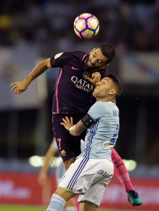 Gelandang Barcelona, Arda Turan (kiri) berebut bola udara dengan bek Celta Vigo, Hugo Mallo pada lanjutan liga Spanyol di Stadion Balaidos, Vigo (3/10).  Celta Vigo berhasil mengalahkan Barcelona dengan skor 4-3. (REUTERS/Miguel Vidal)