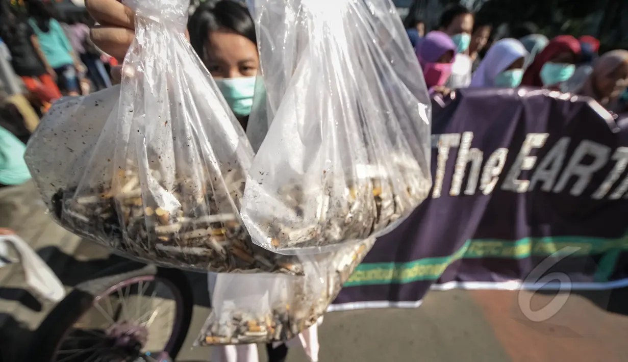 Seorang aktivis menunjukkan puntung rokok yang berhasil dikumpulkan saat Aksi Selamatkan Bumi dari Limbah Puntung Rokok di kawasan Bundaran HI, Jakarta, Minggu (26/4/2015). Kegiatan tersebut untuk memperingati Hari Bumi. (Liputan6.com/Faial Fanani)