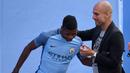 Pep Guardiola  terlihat bercanda dengan pemain anyar Manchester City, Kelechi Iheanacho (kiri) saat perkenalan di City Football Academy, Manchester, (3/7/2016). (AFP/Oli Scarf)