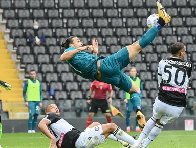 Striker AC Milan, Zlatan Ibrahimovic, mencetak gol dengan tendangan salto ke gawang Udinese pada laga Liga Italia di Stadion Friuli, Minggu (1/11/2020). AC Milan menang dengan skor 2-1. (AFP/Andreas Solaro)