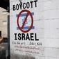 Sebuah tanda di dinding di kota Bethlehem, West Bank, menyerukan pemboikotan produk Israel dari permukiman Yahudi, pada 5 Juni 2015. (Thomas Coex/AFP)