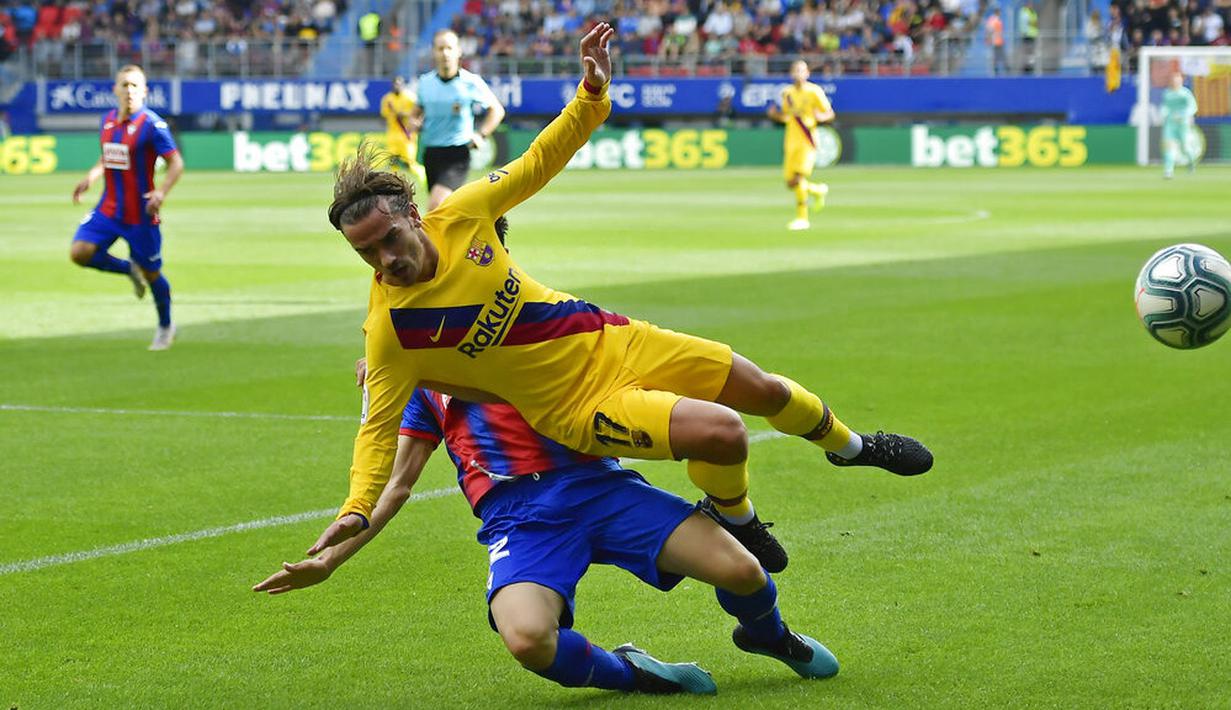 Gelandang Barcelona, Antoine Griezmann, terjatuh saat berusaha melewati pemain Eibar pada laga La Liga 2019 di Stadion Ipurua, Sabtu (19/10). Barcelona menang 3-0 atas Eibar. (AP/Alvaro Barrientos)