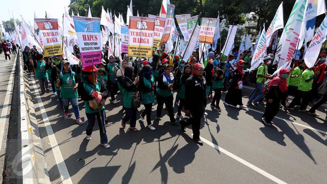 Massa buruh dan pekerja dari berbagai daerah memadati Jalan MH Thamrin, Jakarta, dalam peringatan May Day, Senin (1/5). Dalam aksi ini, buruh menyuarakan sejumlah tuntutan, di antaranya tolak upah murah dan hapus outsourcing. (Liputan6.com/Johan Tallo)