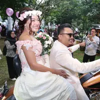 Setelah keliling dengan motor gede, keduanya pun melepas burung merpati dan balon dengan para undangan. Setelah itu, mereka pun langsung naik ke pelaminan dengan diiringi keluarga besar. (Nurwahyunan/Bintang.com)