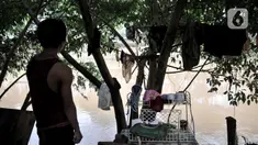 Salah seorang warga berdiri di pinggir bantaran kali usai banjir merendam gubuk miliknya yang berada di pinggir Kanal Banjir Barat (KBB), Jakarta, Rabu (8/1/2020). (merdeka.com/Iqbal S Nugroho)