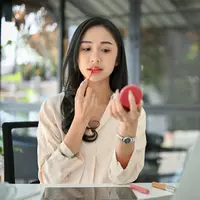 Ilustrasi Perempuan Mengaplikasikan Lipstik. Credit: Shutterstock/BongkarnGraphic