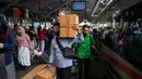Calon penumpang Kereta Api Jarak Jauh (KAJJ) bersiap menaiki rangkaian kereta di stasiun Gubeng, Surabaya, 28 Maret 2025. (JUNI KRISWANTO/AFP)