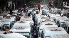 Sopir angkot trayek 44 (Jatinegara-Kampung Melayu-Tebet) melakukan unjuk rasa di sekitar Stasiun Tebet, Jakarta, Senin (12/2).  Angkot M-44 memenuhi jalan akses putaran balik di bawah flyover Tebet hingga menimbulkan kemacetan (Liputan6.com/Arya Manggala)
