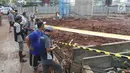 Sejumlah orang melihat lokasi ambruknya tiang girder Tol Bekasi-Cawang-Kampung Melayu (Becakayu) di Kebon Nanas, Jakarta Timur, Selasa (20/2). Sebelumnya, tiang girder Tol Becakayu roboh sekitar pukul 03.40 WIB. (Liputan6.com/Arya Manggala)