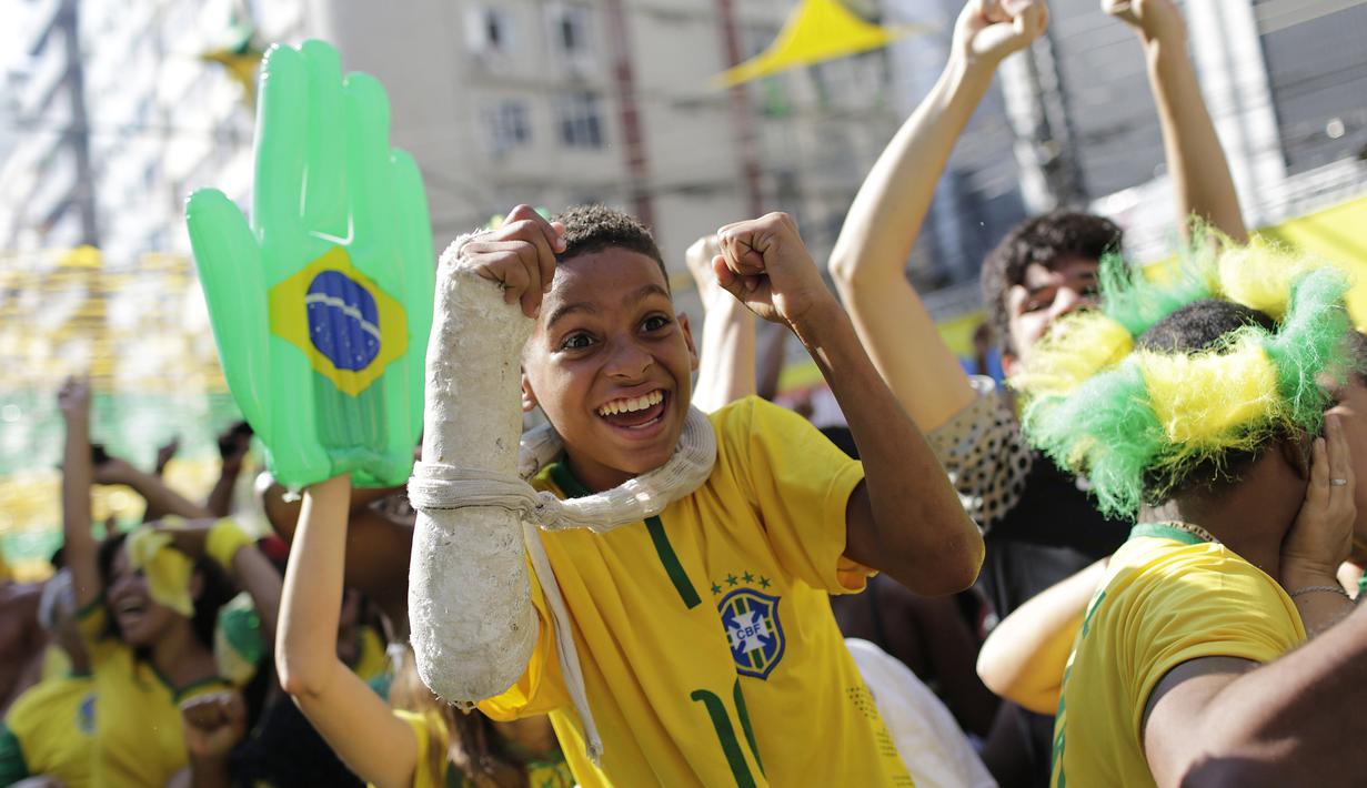 Senyum bahagia fans cilik usai Brasil membobol gawang Kosta Rika pada laga grup E Piala Dunia 2018 di Rio de Janeiro, Brasil, (22/6/2018). Brasil menang 2-0. (AP/Silvia Izquierdo)