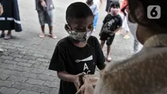 Seorang anak menerima donasi ponsel yang diberikan oleh Komunitas #WartawanLintasMedia saat acara #PonselPintarUntukPelajar di Jakarta, Minggu (9/8/2020). (merdeka.com/Iqbal S. Nugroho)
