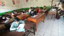 Guru mengawasi murid kelas V saat menjalani ujian Penilaian Akhir Semester (PAS) tahun pelajaran 2020/2021 di Madrasah Ibtidayah (MI) Assu'ada di Pancoran Mas, Depok, Jawa Barat, Selasa (1/12/2020). Ujian dilaksanakan dengan menerapkan protokol kesehatan dalam kelas. (merdeka.com/Arie Basuki)