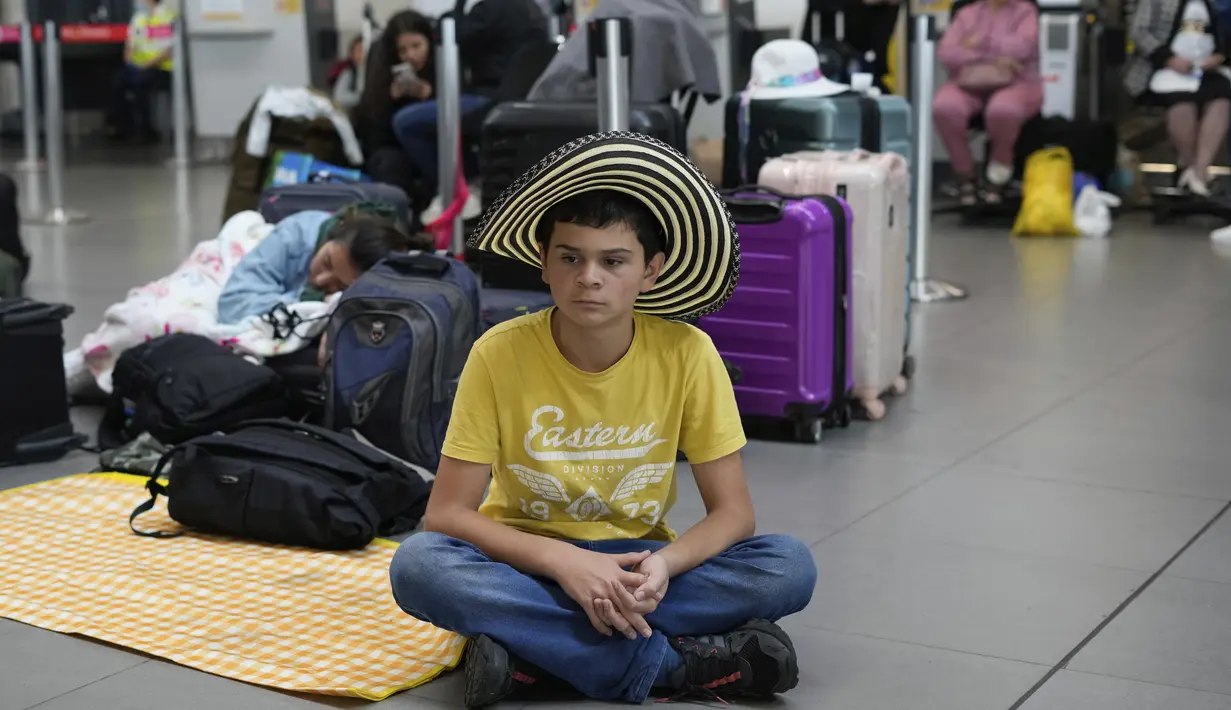 Penumpang Viva Air duduk di area check-in setelah maskapai berbiaya rendah itu menangguhkan operasinya di Bandara Internasional El Dorado di Bogota, Kolombia, Selasa (28/2/2023). Penumpang di Kolombia dengan tiket Viva Air untuk 27 atau 28 Februari atau 1 Maret ke Lima atau Mexico City, akan ditawarkan penerbangan dengan Latam atau Avianca tanpa biaya tambahan, tergantung ketersediaan kursi, kata otoritas tersebut. (AP Photo/Fernando Vergara)