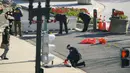 Pihak berwenang menyelidiki tempat kejadian setelah seorang pria menabrakkan mobil ke dua petugas di barikade di Capitol Hill, Washington, Amerika Setikat, Jumat (2/4/2021). Kejadian ini membuat seorang petugas tewas, sedangkan satu lainnya terluka. (AP Photo/Alex Brandon)