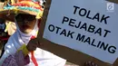 Massa membawa poster saat melakukan aksi menolak Revisi UU KPK di depan Gedung DPR/MPR RI, Jakarta, Rabu (11/9/2019). Mereka menyuarakan pro dan kontra terhadap revisi Undang-Undang Nomor 30 Tahun 2002 tentang Komisi Pemberantasan Tindak Pidana Korupsi. (Liputan6.com/Johan Tallo)
