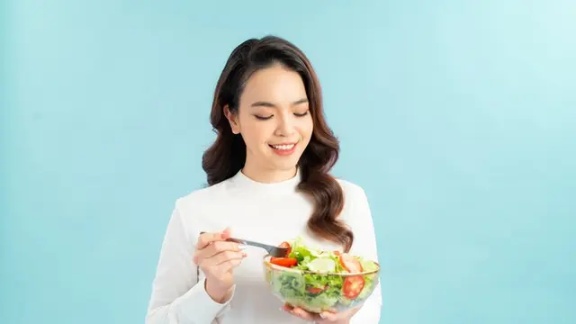 Seorang perempuan sedang memegang semangkuk salad (Freepik/makistock)
