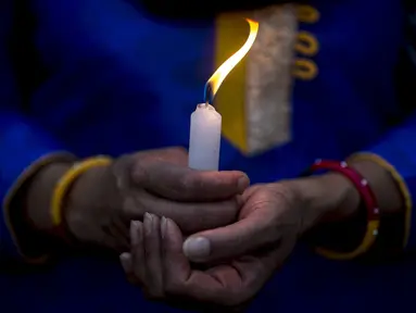 Seorang wanita menyalakan lilin untuk menghormati para korban gempa Nepal di Boudha Stupa, Kathmandu, Nepal, (7/5/2015). Gempa berkekuatan 7,8 yang meluluhlantakkan Nepal pada 25 April 2015 lalu. (REUTERS/Athit Perawongmetha)