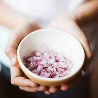 Ilustrasi mengiris bawang merah. (dok. unsplash.com/Asnida Riani)