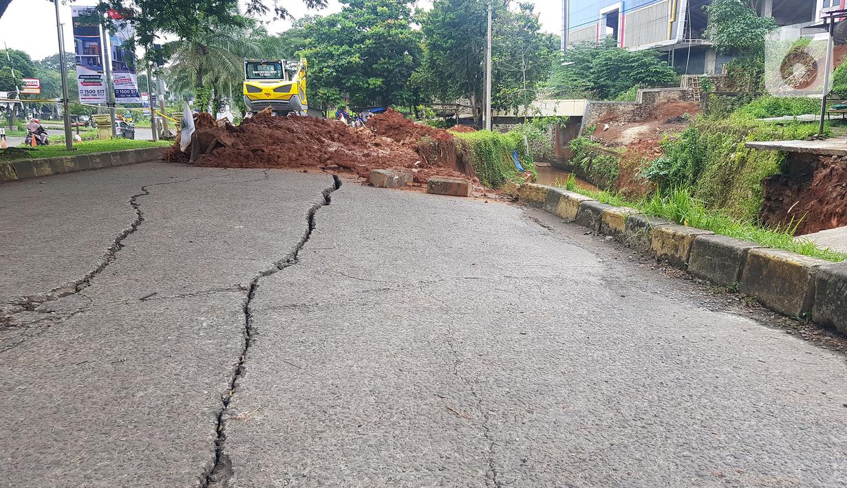 Jalan ambles di ruas Jalan Boulevard, Grand Depok City (GDC), Kota Depok, Jawa Barat, Selasa (13/4/2021). Jalan ambles terjadi setelah wilayah tersebut diguyur hujan lebat tadi malam dan mengakibatkan satu ruas jalan terpaksa ditutup sementara karena membahayakan. (Liputan6.com/Herman Zakharia)