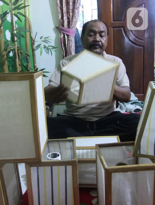 Nana Suryana (52), perajin lampion hias, mengerjakan pesanan konsumen di kawasan Benda, Kota Tangerang. Selasa (9/3/2021). Lampion hasil karyanya dibanderol dengan harga bervariasi mulai dari Rp 50ribu hingga Rp 1 juta. (Liputan6.com/Angga Yuniar)