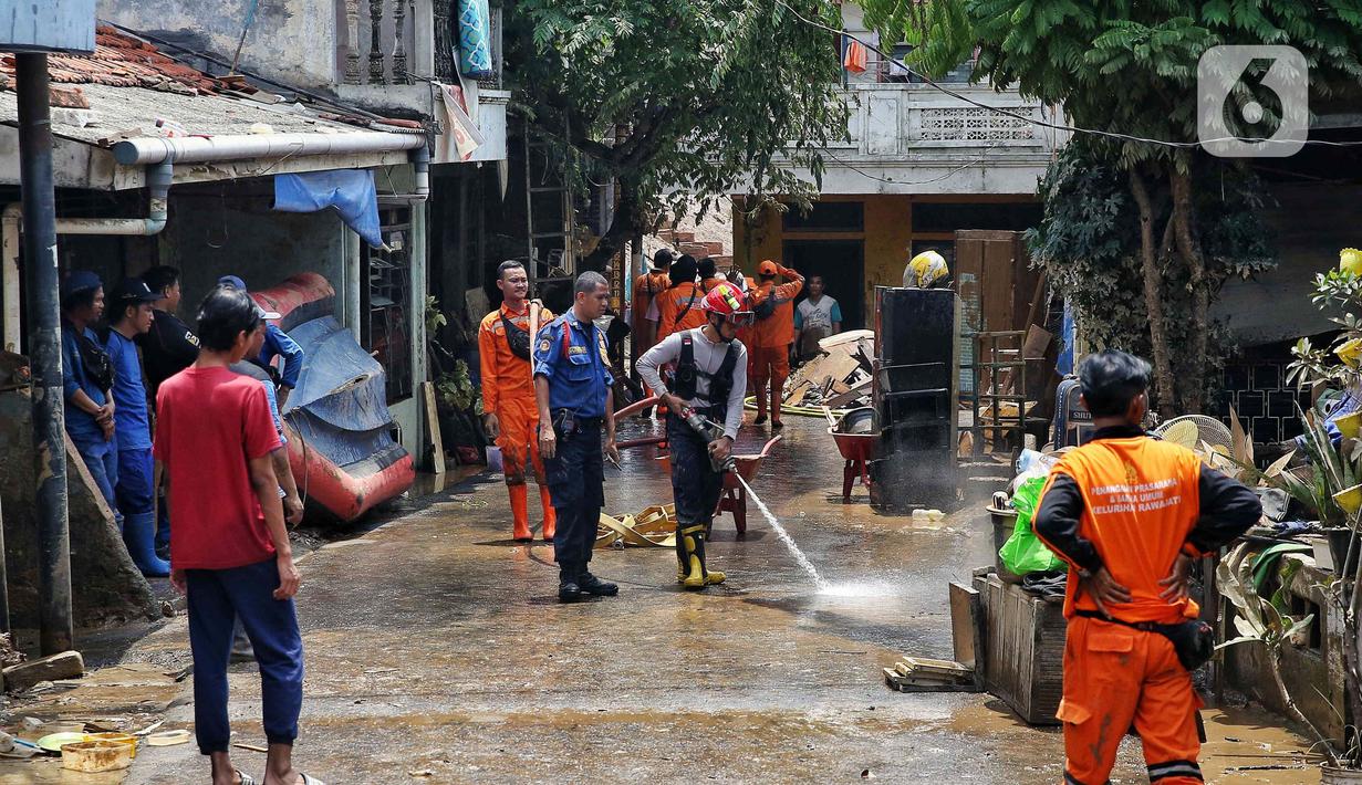 Personel dari Dinas Penanggulangan Kebakaran dan Penyelamatan (Gulkarmat) Provinsi DK Jakarta menyemprotkan air untuk membersihkan endapan sisa lumpur di permukiman warga di kawasan Rawajati, Kalibata, Jakarta Selatan, Jakarta, Rabu (5/3/2025). (Liputan6.com/Angga Yuniar)