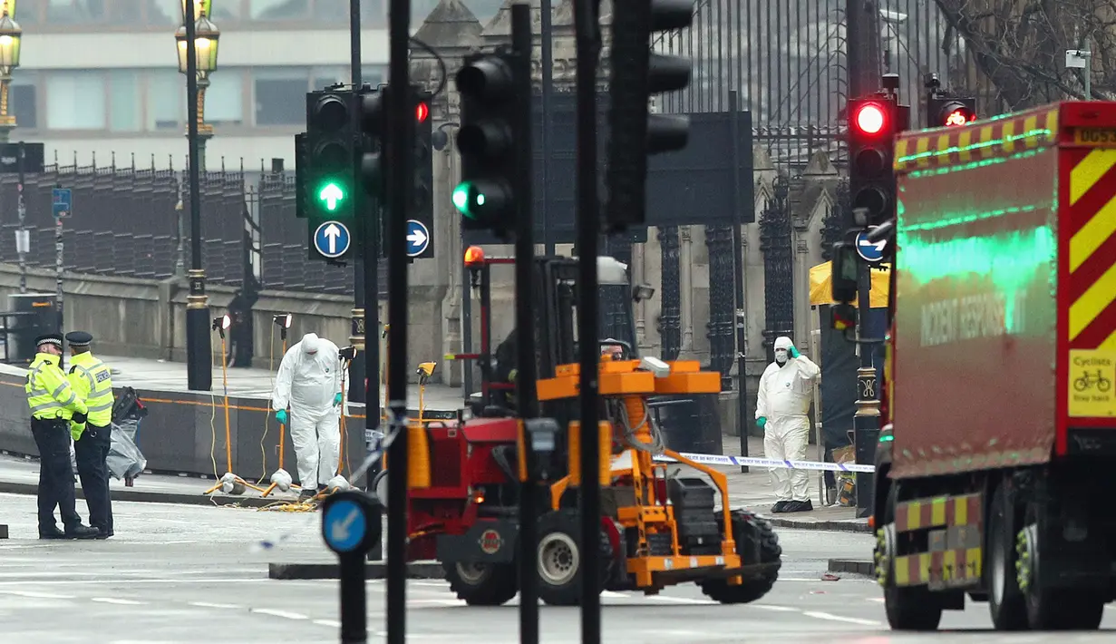 Petugas forensik meneliti lokasi serangan teror Inggris di dekat gedung parlemen di London, Rabu (22/3). Sedikitnya lima orang tewas dalam serangan teror di Jembatan Westminster dan di dekat Gedung Parlemen itu. (Jonathan Brady/PA via AP)