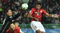 Gelandang Guangzhou Evergrande, Paulinho, duel udara dengan kiper America, Moises Munoz, pada laga perempat final Piala Dunia Antarklub di Osaka, Minggu (13/12/2015). (AFP/Kazuhiro Nogi)