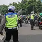 Petugas kepolisian lalu lintas memberhentikan pengendara motor saat Operasi Zebra Jaya 2020 di kawasan Cawang, Jakarta, Senin (26/10/2020). Operasi Zebra Jaya dilaksanakan pada 26 Oktober-8 November 2020 untuk menekan jumlah pelanggaran lalu lintas. (Liputan6.com/Faizal Fanani)