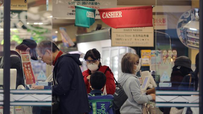 Pelanggan mengantre untuk melakukan pembayaran di sebuah supermarket di Shinagawa-ku di Tokyo, Jepang (8/4/2020). Tidak seperti biasanya, kota-kota besar di Jepang, termasuk ibu kota Tokyo, tampak sepi dengan banyak toko tutup dan hanya sedikit orang berada di jalanan pada Rabu (8/4). (Xinhua/Du Xia